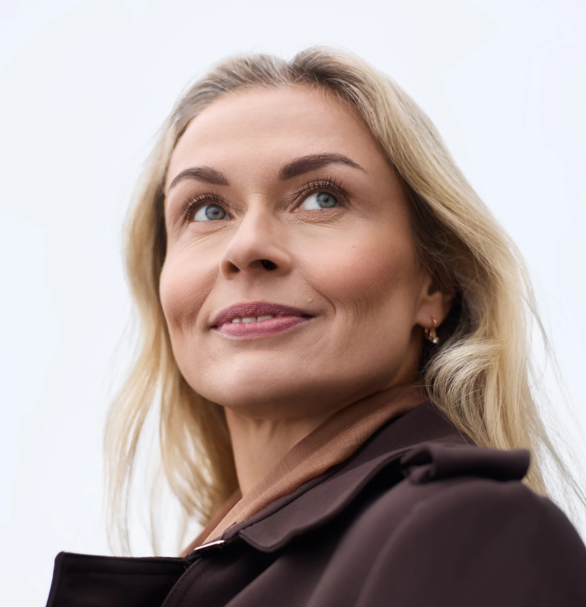A smiling woman in her forties looking up